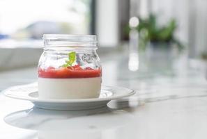 Panna cotta de postre casero con salsa de fresa foto