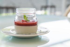 Panna cotta de postre casero con salsa de fresa foto