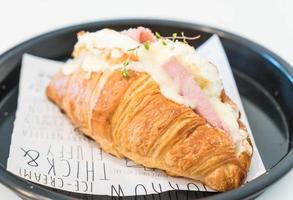 Croissant ham cheese on plate photo