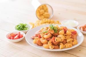 Macaroni with sausage on the table photo