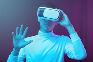 Young Asian man wearing virtual reality goggle watching 360 degree vdo