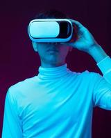 Young Asian man wearing virtual reality goggle watching 360 degree vdo