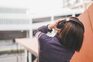 Happy young asian woman listening to music with headphones photo