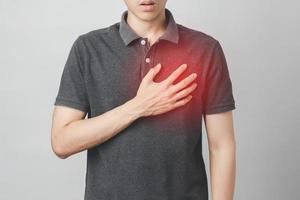 El hombre tiene dolor en el pecho que sufre de enfermedad cardíaca, enfermedad cardiovascular. foto