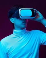 Young asian man wearing virtual reality goggles watching 360 video photo