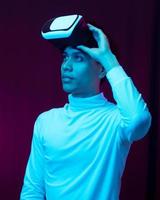 Young asian man wearing virtual reality goggles watching 360 video photo