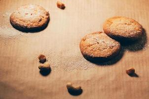 Round biscuits on baking paper background, with nuts and flour photo