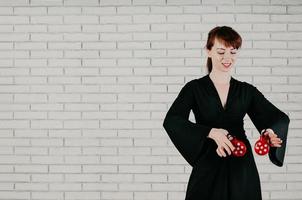 mujer joven y atractiva en vestido negro, bailando, castañuelas rojas, sonriendo foto