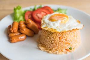 Fried rice with sausage and fried egg on the table photo