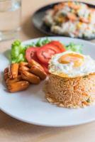 Fried rice with sausage and fried egg on the table photo