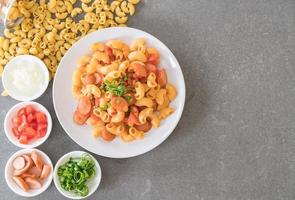 Macaroni with sausage on the table photo