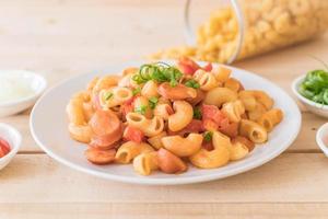 Macaroni with sausage on the table photo