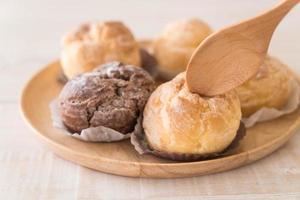 Cream puff on wood plate photo