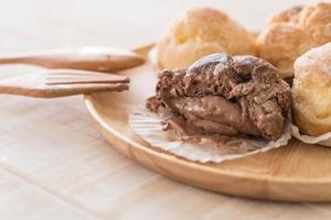 Cream puff on wood plate photo