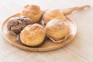 Cream puff on wood plate photo