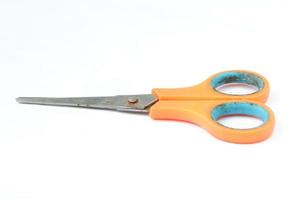 Closeup shot of scissors with orange handles isolated on a white photo