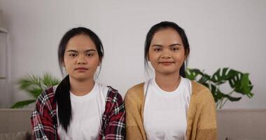 Twin Girls Smiling and Sitting on Couch in Living Room video