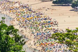 playa de copacabana llena en un típico domingo soleado en río de janeiro.