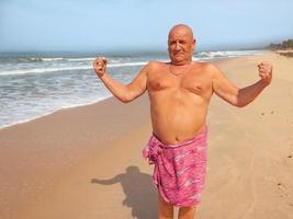 Italian old man is showing the muscles of his arms, jokingly photo