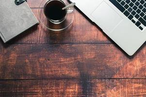 Coffee mug, notebook computer, book at the desk. photo