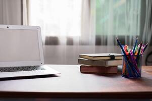 A laptop sitting on a desk with a cup of coffee photo