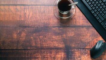 Coffee cup, keyboard, mouse at the desk. photo