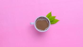 taza de café sobre un fondo rosa foto