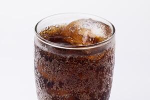 Cola in glass with clear ice cubes isolated on white background photo