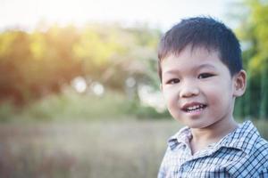 Close up of cute asian boy playing and smiling outdoors. photo