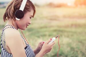 Mujer sexy relajada respirando y escuchando música desde un teléfono inteligente foto