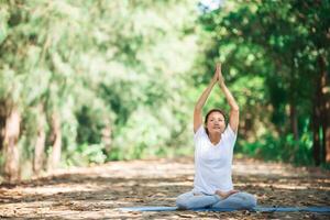 Young asian woman doing yoga in the morning at the park. photo