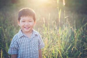 niño asiático feliz jugando al aire libre. lindo asiático. chico en el campo. foto