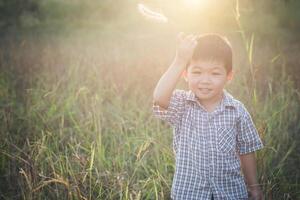 Happy little asian boy playing outdoors. Cute asian. boy on field. photo