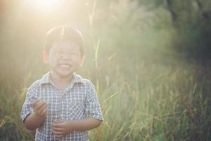 niño asiático feliz jugando al aire libre. lindo asiático. chico en el campo. foto
