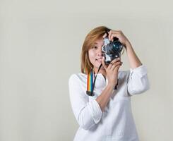 Beautiful young woman photographer holding retro camera photo