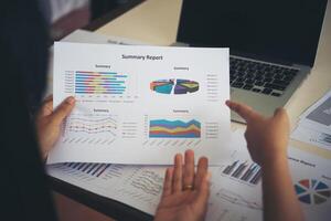 Businessman and woman discussing on stock market charts in office. photo