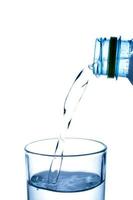 vertiendo agua de la botella en un vaso foto
