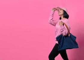 Portrait of happy young Asian woman holding bag while shopping photo