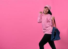 Portrait of happy young Asian woman holding bag while shopping photo