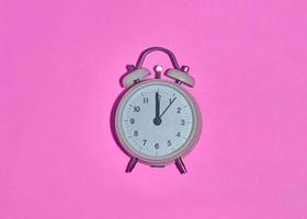 vintage alarm clock on light pink background photo