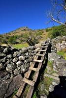 Wooden ladder over the dry stone wall photo