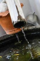 Water pouring from bamboo tube to below photo