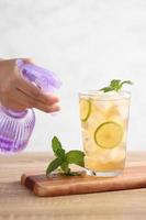 Food stylist use sprayer decorating iced tea with lemon photo