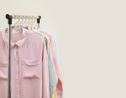 Pastel shirts hanging on rack in shop and freespace for text photo
