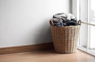 Wooden basket with dirty laundry on floor