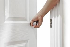 Man hand open door knob or opening white door photo