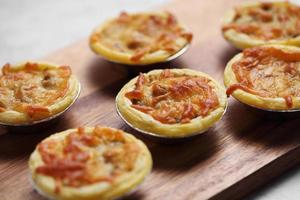 Mini pie from meat and mushrooms in wooden tray photo