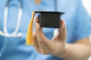 estudio médico asiático aprender con sombrero de graduación en el hospital foto