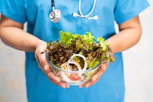 Nutritionist doctor holding various healthy fresh vegetables photo