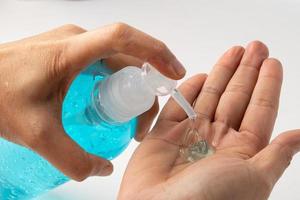 Asian working woman washing hand by press blue alcohol sanitizer gel photo